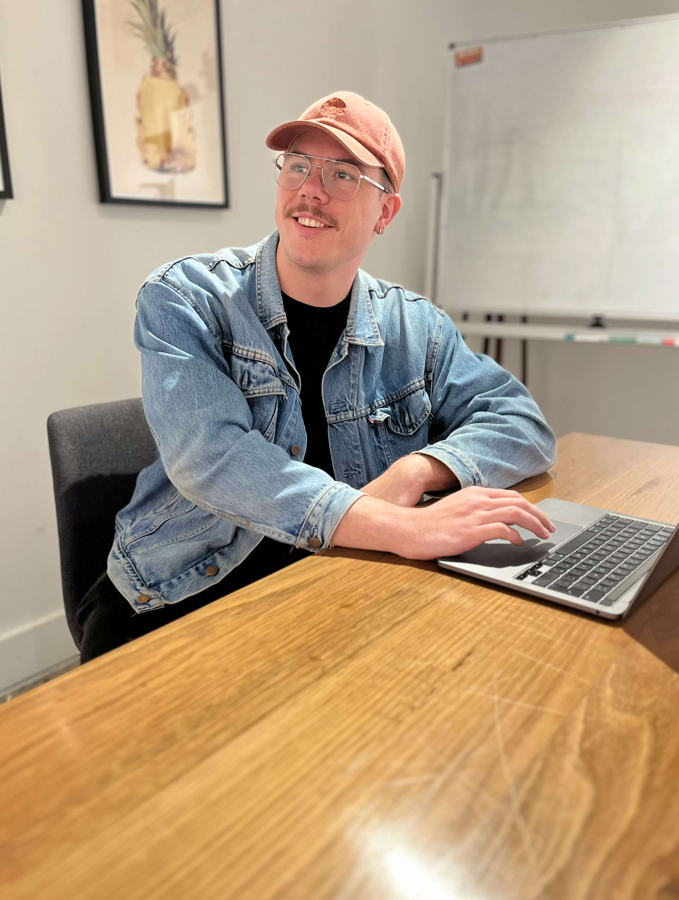 Jack Christian smiling while building a website on his laptop